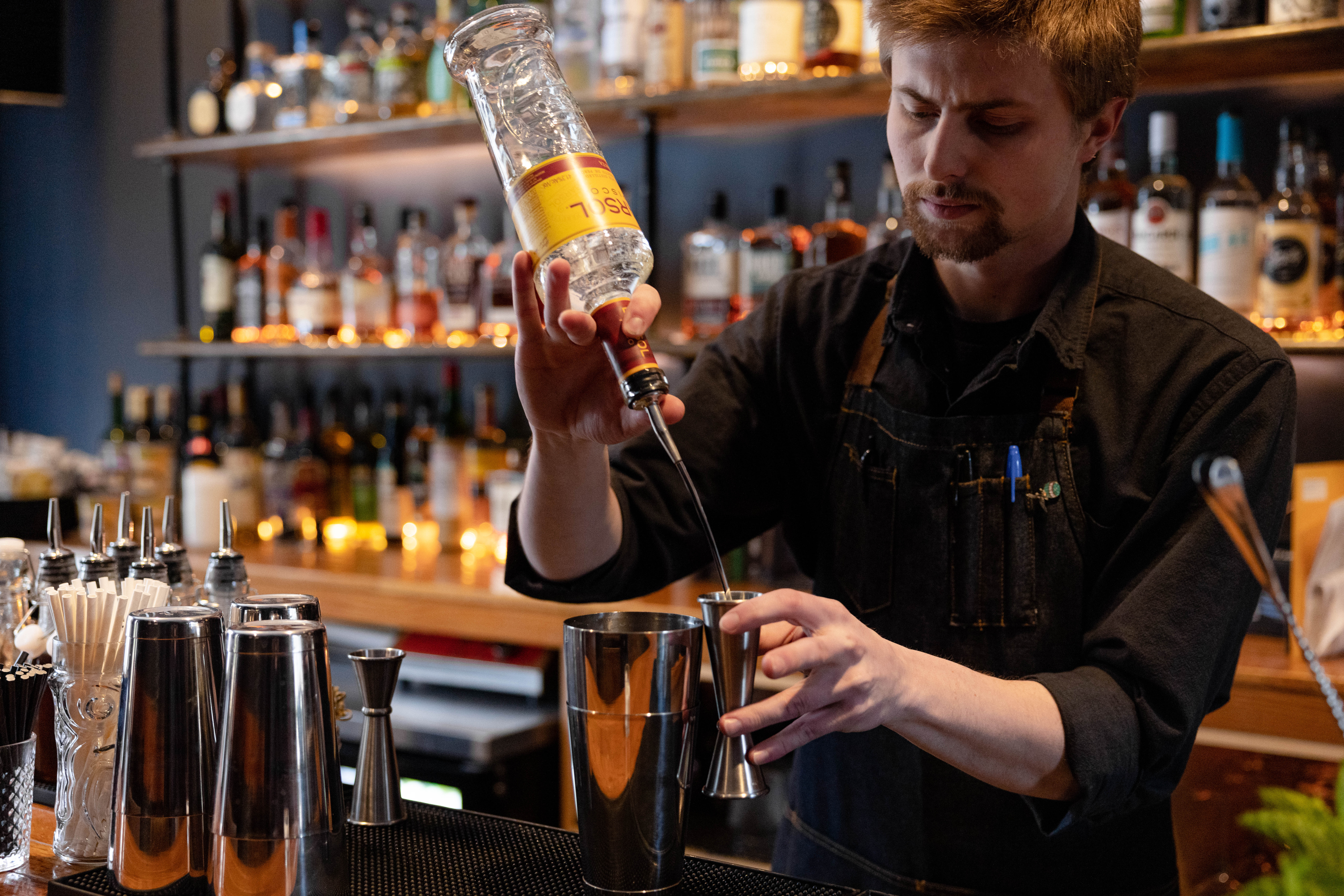 Bartender measuring alcohol to mix a drink