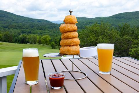 beers and onion rings on an outdoor dining table