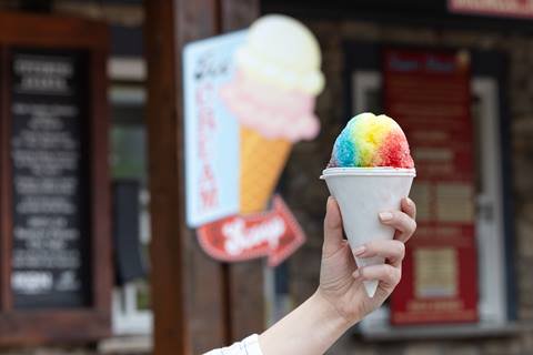 rainbow snow cone in front of ice cream sign