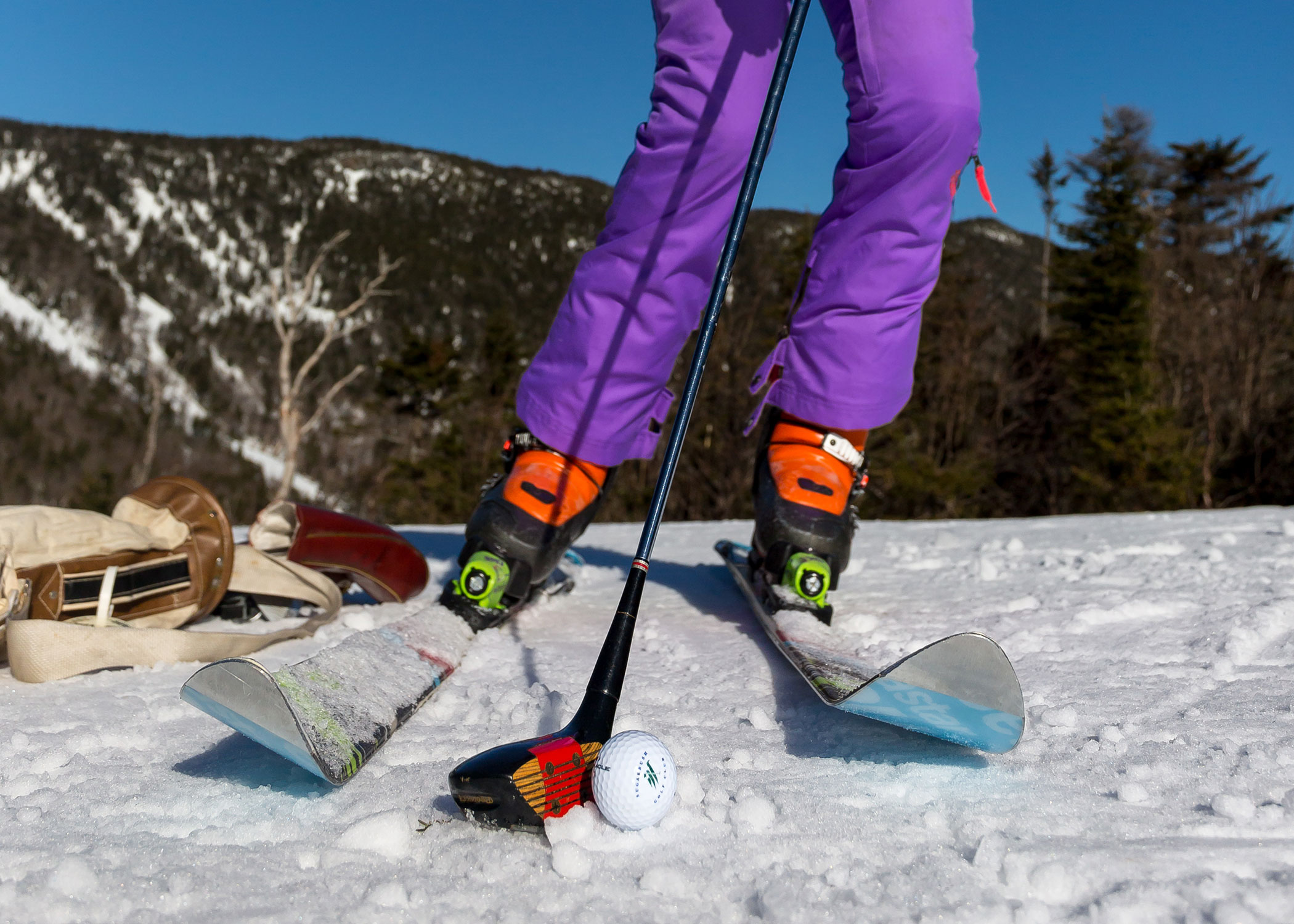 Skis and golf ball on snow