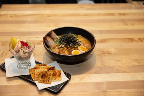 ramen bowl with toppings and shrimp and crackers on the side