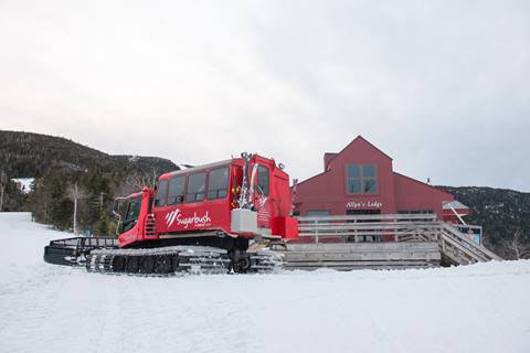 Exterior shot of Allyns lodge with a Snowcat out front