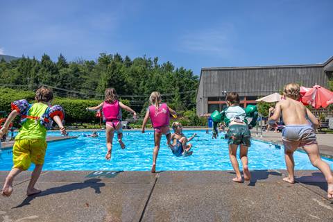 Kids jumping into a swimming pool