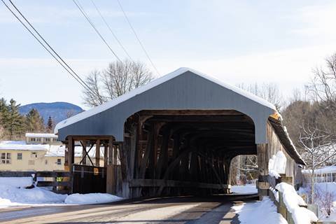 Exterior shot of a covered bridge with snow on it