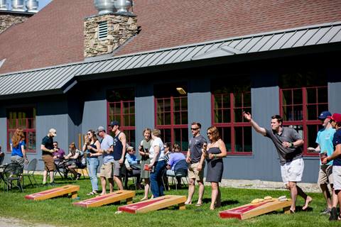 Group of people playing mulitpule games of cornhole