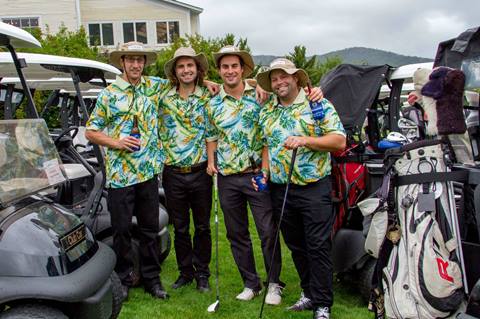 Group of glofers in matching shirts next to golf carts