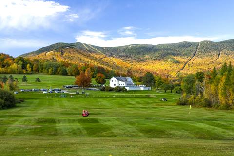 Golf course greens with sugarbush resort in the background