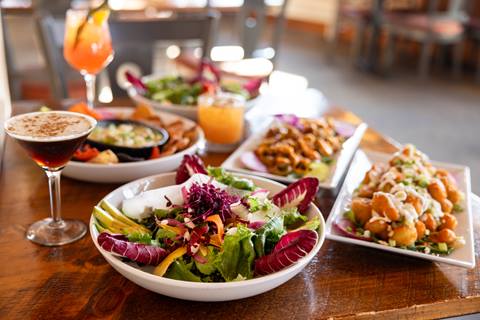 Closeup of a table full of plates of food and drinks at Rumble's Bistro and Bar