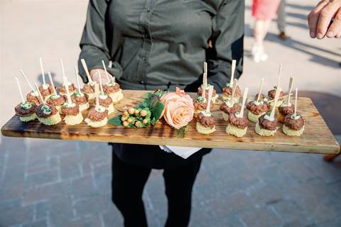 Close up of a person holding a platter of food outside
