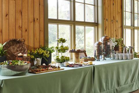 grazing table with green table cloth and greenery