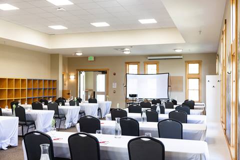 Tables set up for an event inside the Schoolhouse at Sugarbush Resort