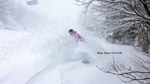snowboarder riding through powder