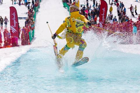 Skier in Lawson's Finest Liquids Outfit crossing the pond at Pond Skim