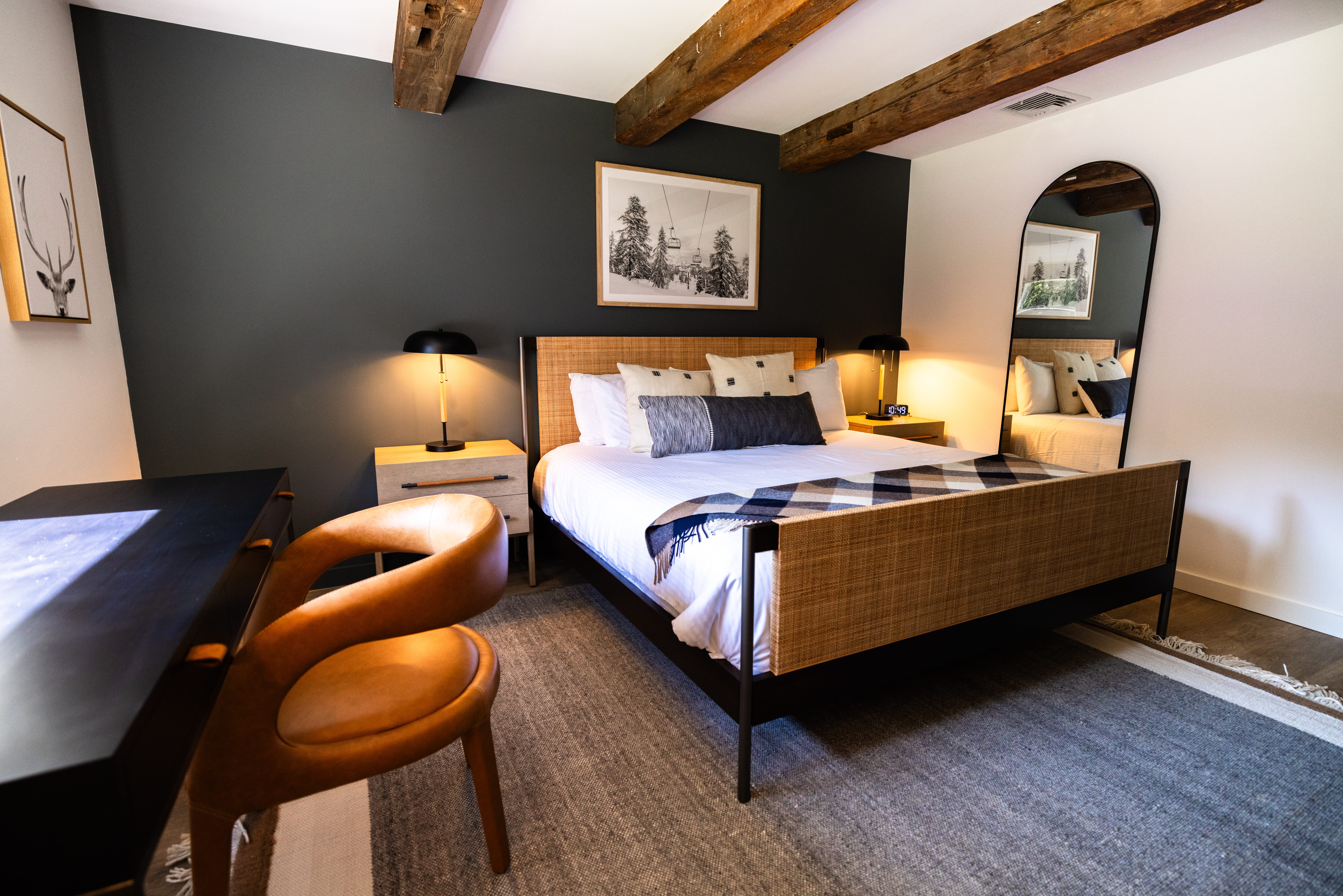 king guest room with desk and wooden beam accents