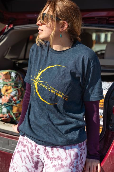 girl posing in front of car with solar eclipse shirt