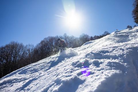 Skier on soft snow on a bluebird sunny day