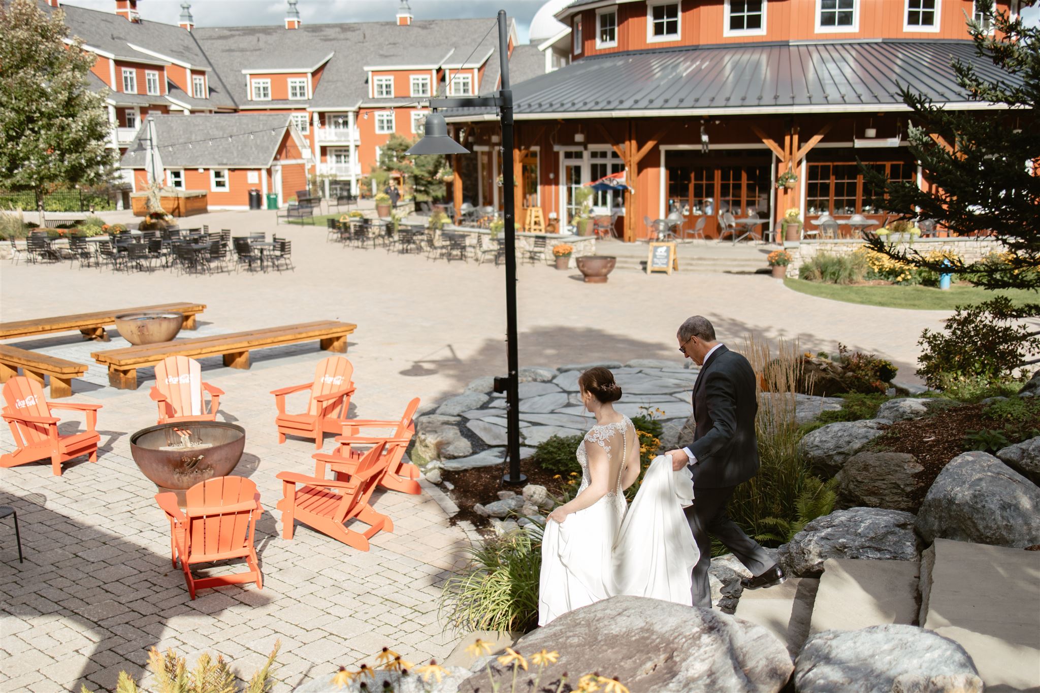 Groom carries Bride's train walking through Lincoln Peak Courtyard