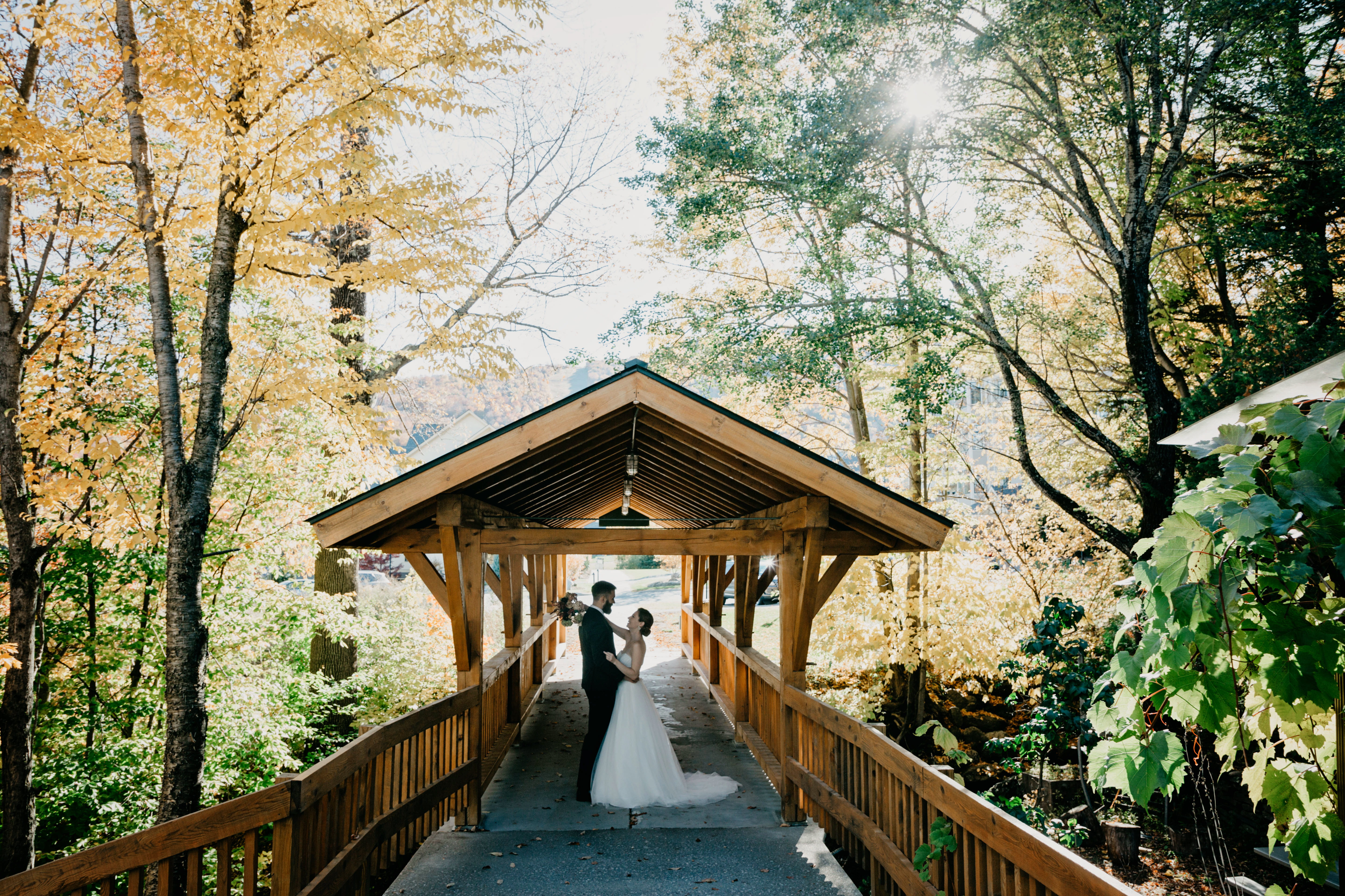 Bride and Groom Pose under Covered bridge in Sugarbush Village