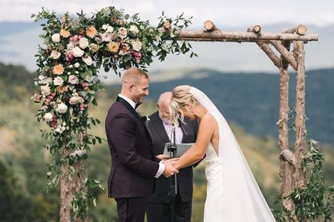 Bride and Groom under arbor at mountaintop ceremony space