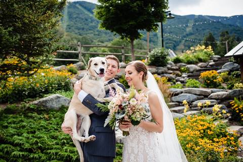 Bride and Groom pose with dog in Lincoln Peak Courtyard