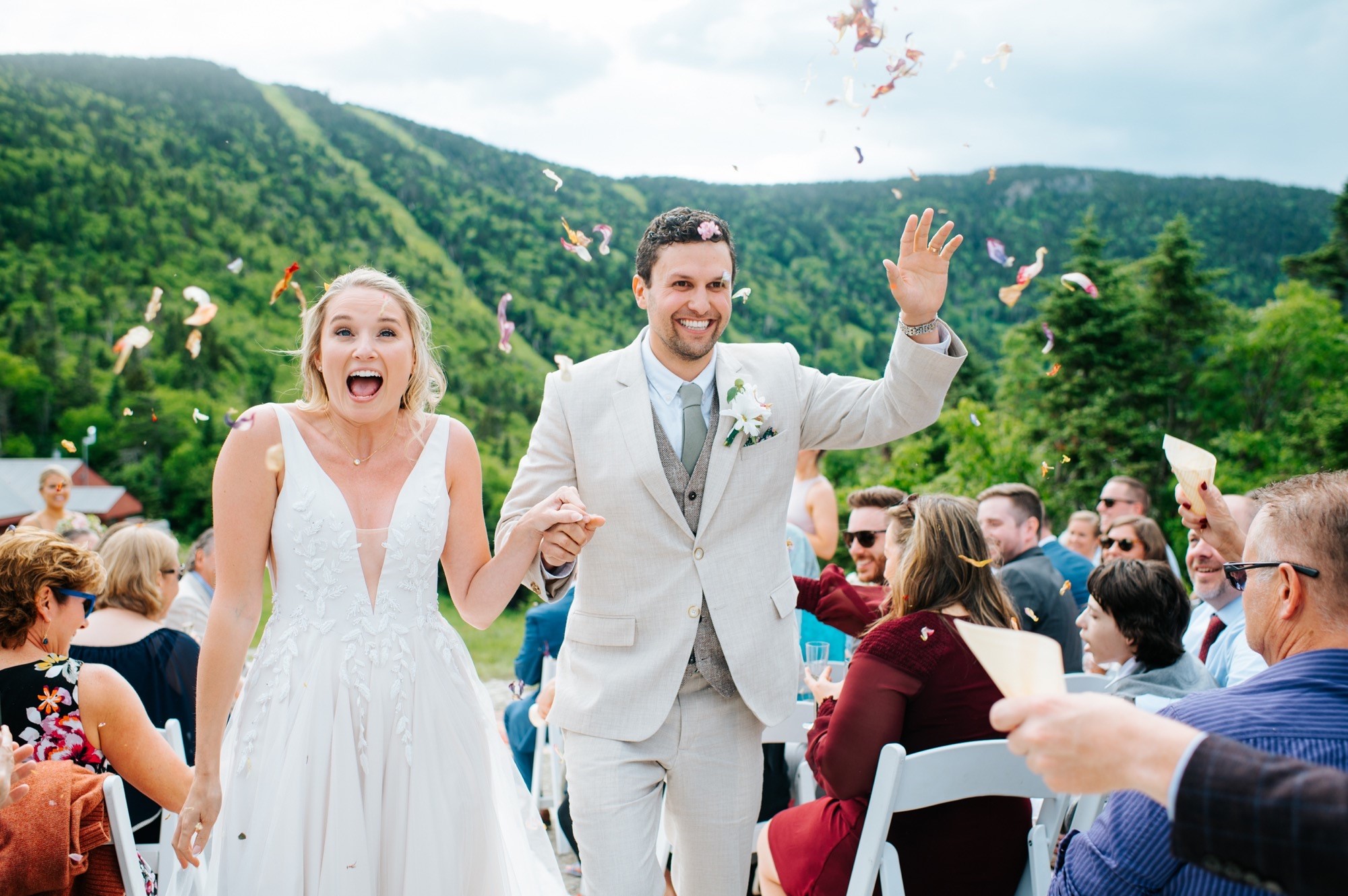 Bride and Groom have flower petals tossed as they walk down the aisle