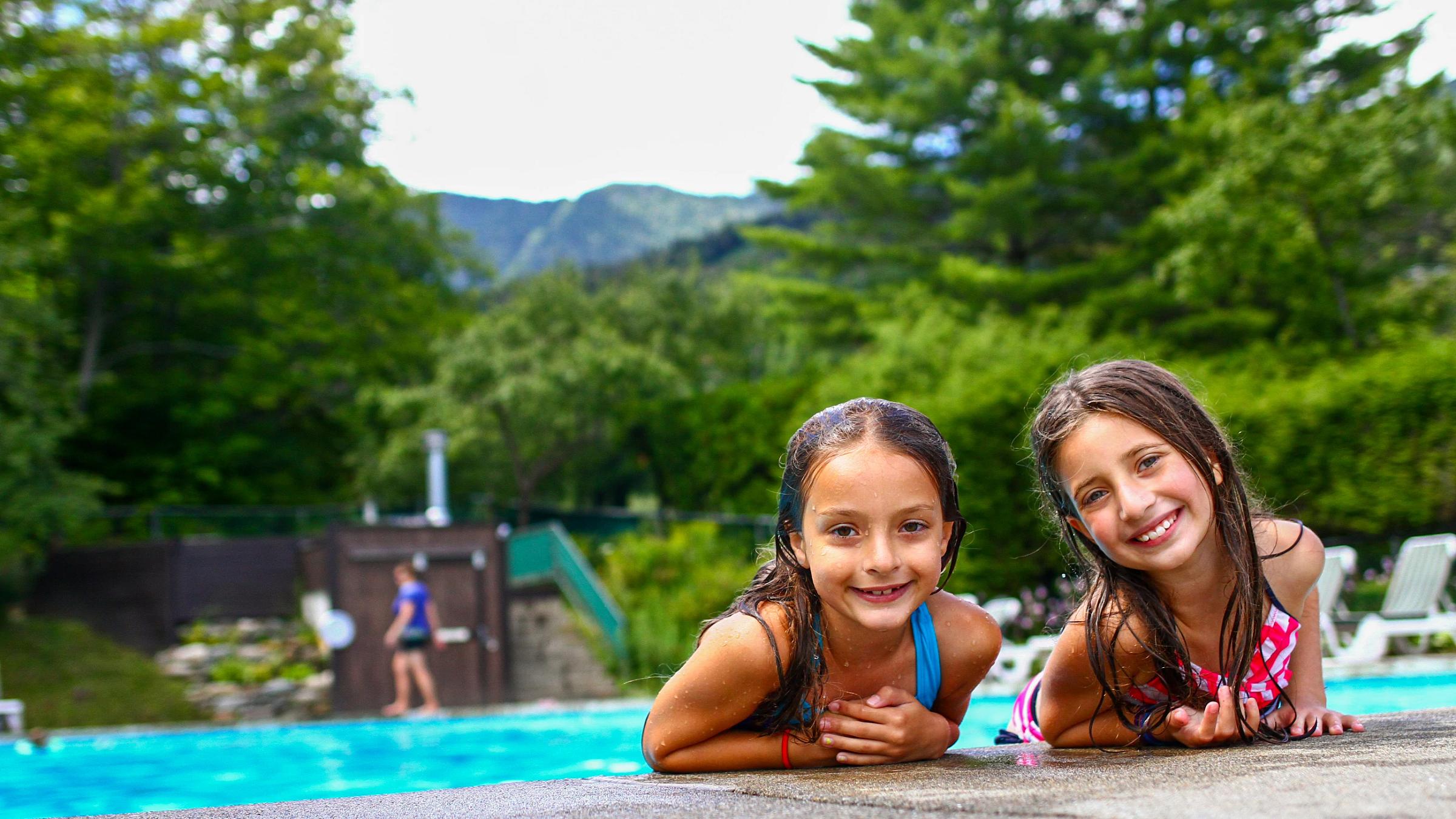 two young friends smiling at the pool